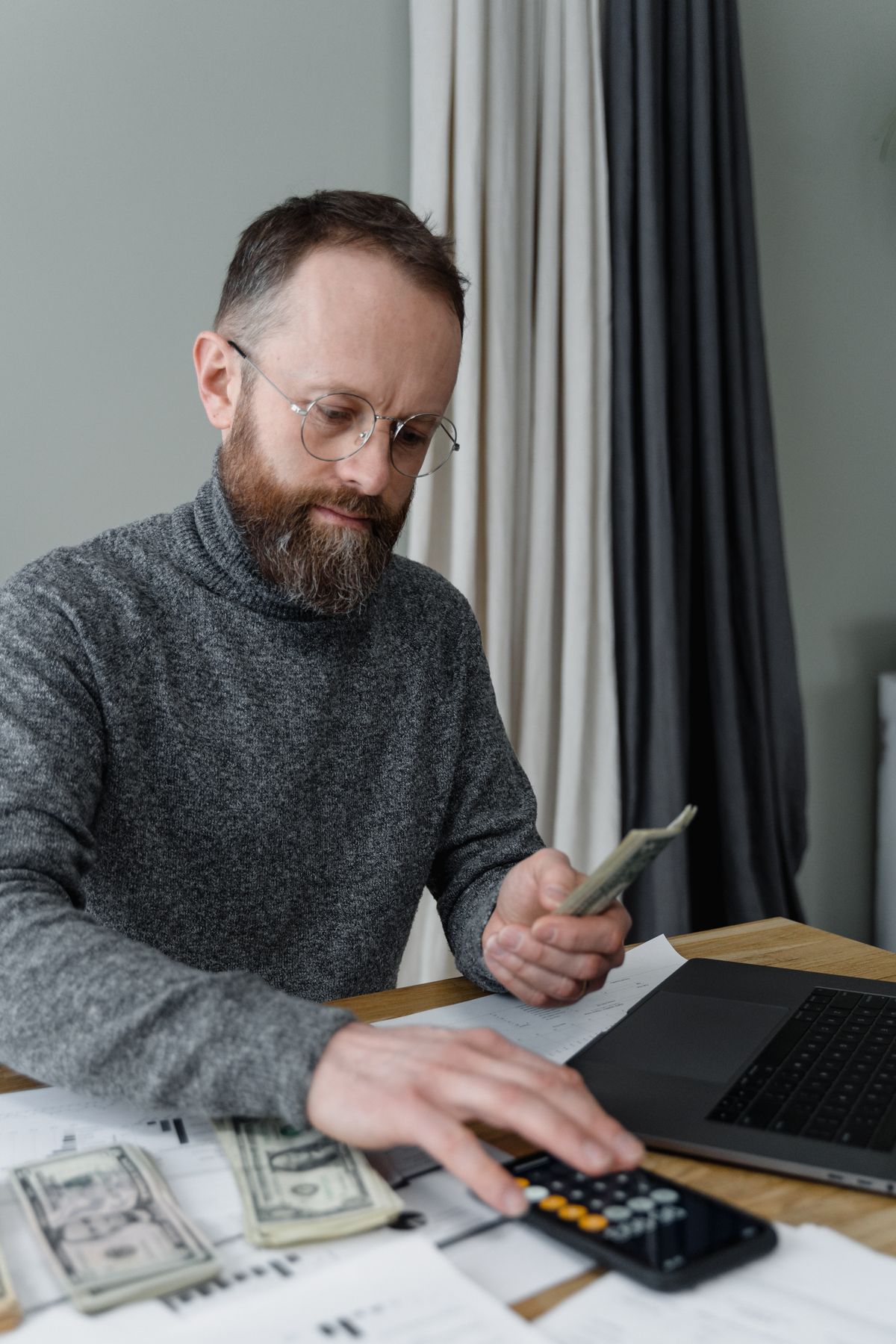 Un hombre organiza sus cuentas con una calculadora y su computadora